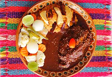 Un plato de mole con pollo y verduras