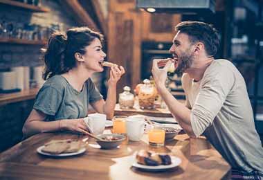 Pareja comiendo sánduches, uno de los desayunos fáciles y rápidos