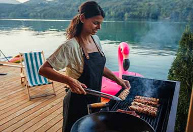 Una mujer asando carne.