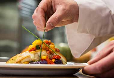 Un pescado cocinado con verduras.