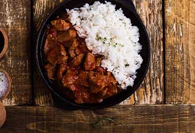 Una carne que pasó por un proceso de cocción mixta, acompañada de arroz.