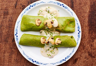 Champiñones con salsa blanca, acompañando unas crepes.