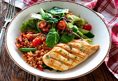 Pollo con sus guarniciones: arroz rojo y ensalada.