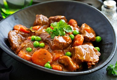 Arvejas, un alimento enlatado común, en un plato de carne