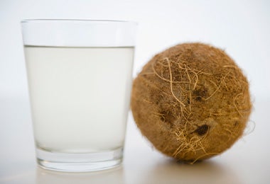 Agua de coco con la fruta a su lado