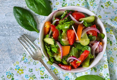 Ensalada con base de hojas verdes, con zanahoria y cebolla, una comida fácil de hacer