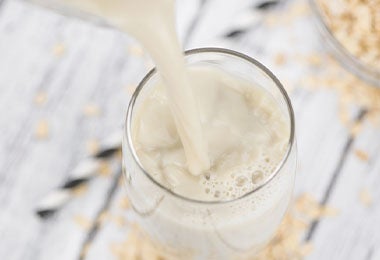 Leche de avena en un vaso, una alternativa vegana para remplazar la leche de origen animal. 