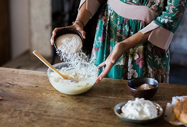 Mujer añadiendo harina a su mezcla de crema pastelera