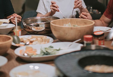 Familia compartiendo dumplings y otros platillos asiáticos