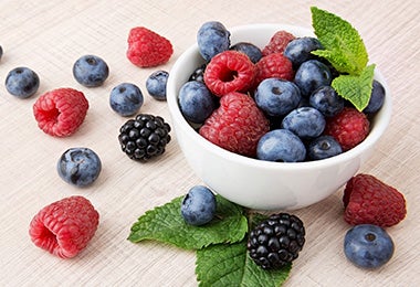 Un bowl pequeño lleno de arándanos, moras y frambuesas
