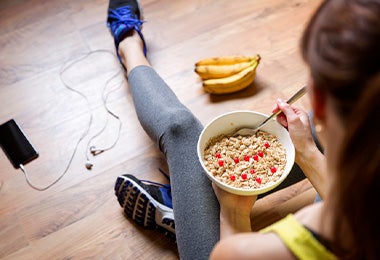 Mujer comiendo avena y plátano antes de hacer ejercicio