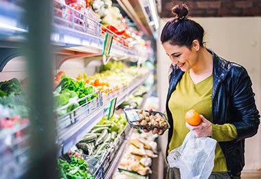 Mujer comprando champiñones y frutas supermercado clasificación alimentos 