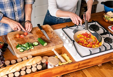 Pareja cocinando pan y vegetales contaminación cruzada