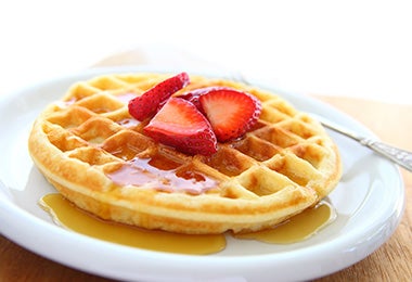 Un waffle tradicional con frutas y miel, una receta deliciosa