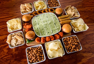 Mesa con snacks fáciles, como frutos secos y papas, para ver deportes