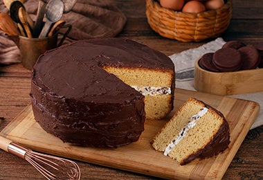 Mesa con torta de cumpleaños de vainilla con cobertura de chocolate 