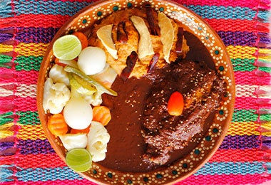 Un plato de mole con pollo y ensalada, muy famoso en el turismo gastronómico de México