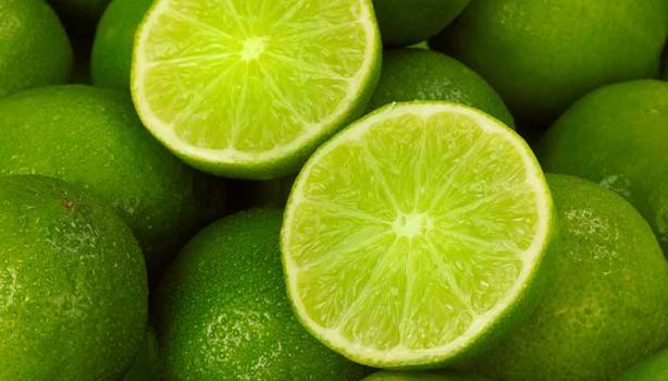 Un limón, uno de los cítricos más usados, partido por la mitad, encima de más limones.