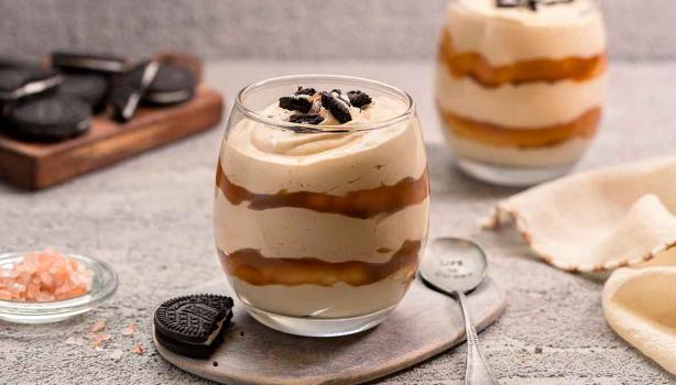 Postre de limón en vaso, decorado con frutas.