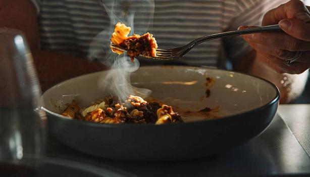 Una persona comiendo un plato de pasta, una de las comidas fáciles de hacer