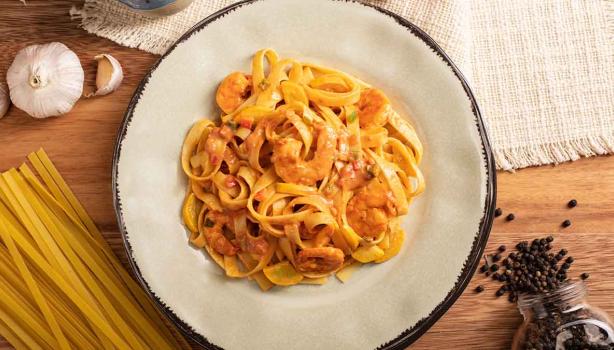 Plato de pasta con camarones, tomate, ajo y pimienta comida italiana
