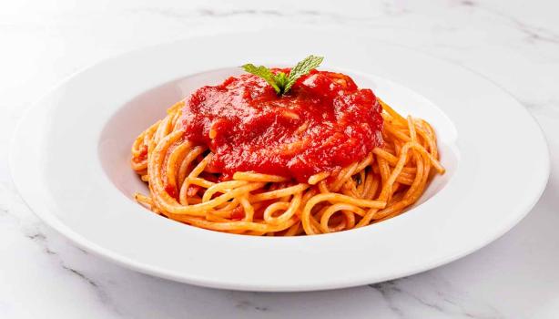 Espagueti con salsa pomodoro, servido en un plato blanco