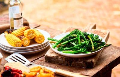 Mazorcas y espárragos sobre una mesa de madera en un asado vegetariano Mazorcas y espárragos sobre una mesa de madera en un asado vegetariano
