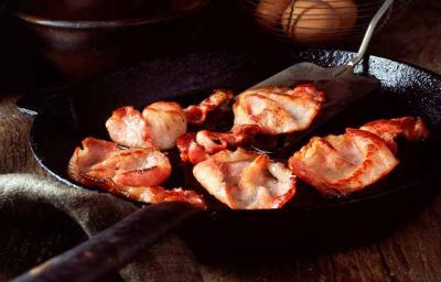 Tocineta siendo cocinada en una sartén. Tocineta siendo cocinada en una sartén.