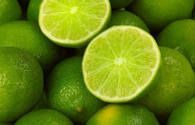 Un limón, uno de los cítricos más usados, partido por la mitad, encima de más limones.