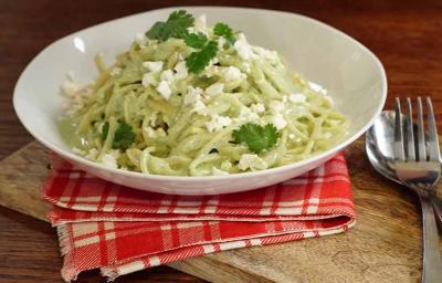 Pasta aromatizada con culantro, servida en un plato blanco. Pasta aromatizada con culantro, servida en un plato blanco.