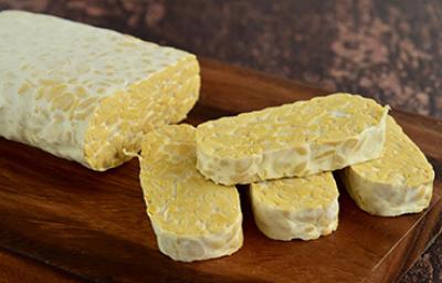 Tempeh, una carne vegetal, sobre una mesa de madera. Tempeh, una carne vegetal, sobre una mesa de madera.