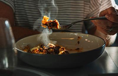 Una persona comiendo un plato de pasta, una de las comidas fáciles de hacer