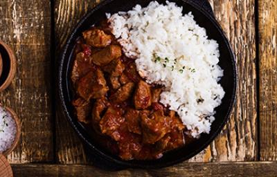 Carne en cuadros y arroz blanco en una sartén de hierro Carne en cuadros y arroz blanco en una sartén de hierro