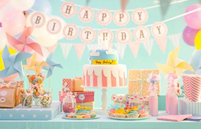 Celebración de cumpleaños con variedad de postres en una mesa de dulces