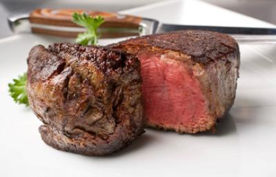 Carne Angus asada con hojas de perejil en un plato Carne Angus asada con hojas de perejil en un plato