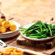 Mazorcas y espárragos sobre una mesa de madera en un asado vegetariano