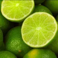 Un limón, uno de los cítricos más usados, partido por la mitad, encima de más limones.