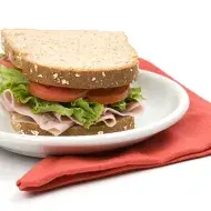 Un sándwich clásico de jamón, lechuga y tomate, uno de los snacks balanceados más populares