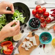 Una persona preparando una ensalada navideña, deliciosa y colorida.