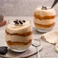 Postre de limón en vaso, decorado con frutas.