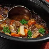 Estofado de carne y verduras siendo preparado en una olla de cocción lenta