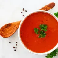 Crema de tomate con perejil, una de las recetas más famosas, servida con una cuchara de madera
